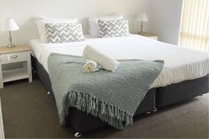 a bed with a blanket and a towel on it at Suburban Bliss - Elegant Villa 1 in Wagga Wagga