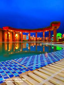 - une piscine avec kiosque la nuit dans l'établissement Hotel Ashiana Lagoon, à Purî