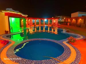 - une piscine au milieu d'une maison la nuit dans l'établissement Hotel Ashiana Lagoon, à Purî