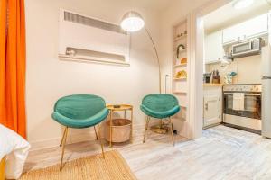 two green chairs and a table in a kitchen at Riverside Luxe: Stylish Designer Retreat in Reno