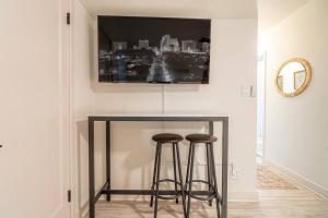 a table with two bar stools and a tv on the wall at Riverside Luxe: Stylish Designer Retreat in Reno