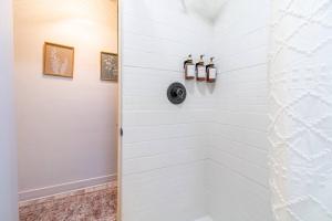 a shower in a bathroom with a white wall at Riverside Luxe: Stylish Designer Retreat in Reno +7 photos