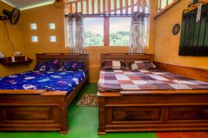 2 camas individuales en una habitación con ventana en Rainforest View, en Deniyaya