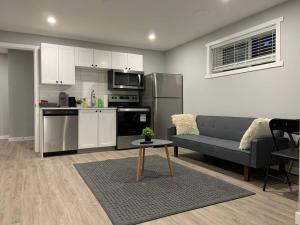 a kitchen and living room with a couch and a table at Guest Suite in Regina - Feels like home in Regina