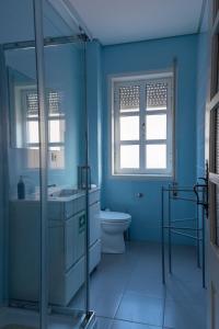 uma casa de banho azul com um WC e um lavatório em North Star Flats @ Dom Luís I Bridge em Vila Nova de Gaia