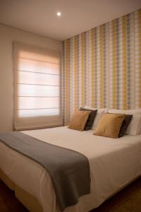 um quarto com uma grande cama branca e uma janela em North Star Flats @ Dom Luís I Bridge em Vila Nova de Gaia
