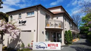 クライストチャーチにあるDelago Motel/Apartmentsの前に看板がある白い建物