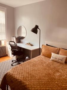 Schlafzimmer mit einem Bett, einem Schreibtisch und einer Lampe in der Unterkunft Private Rooms in TownHouse w Shared Baths Qn Bed 1-3ppl in Unionport