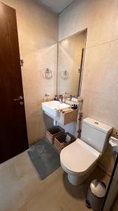 a bathroom with a toilet and a sink at Cozy Central Apt with Parking and Skyline View in Dubai