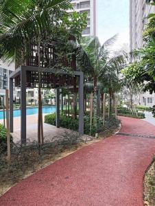 a red walkway with palm trees in a city at D-29-08 / Youth City / Nilai / Infinity pool in Nilai