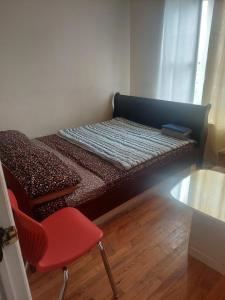 a small bed with a red chair in a room at Cosy Bedroom 12mins to Airport Prudential NJIT UMDJ Penn Station in Newark