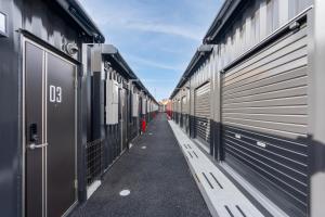 a row of metal garages lined up next to each other at HOTEL R9 The Yard 藤岡 in Fujioka