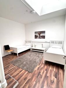 a white room with two beds and a rug at Ganze Citywohnung 4 Schlafzimmer in Hannover +14 photos
