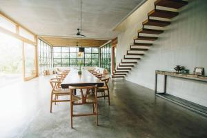 a dining room with a table and chairs and a staircase at ZIN Berawa Villas & Bungalows in Canggu