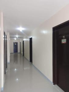 un corridoio di un edificio con pareti bianche e porte nere di Baie Benie Beach Resort a Balibago