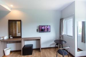 Una habitación con un espejo, una mesa y sillas. en PhetPhangan Hotel, en Ban Tha Kup
