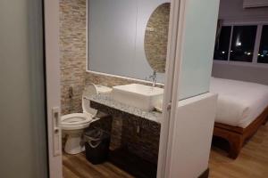 Un baño con lavabo, inodoro y una cama. en PhetPhangan Hotel, en Ban Tha Kup