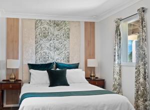 Un dormitorio con una cama grande y una ventana en Mapleton Park Cottage en Springwood