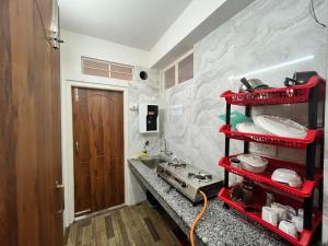 uma prateleira vermelha numa cozinha com um lavatório em Mulberry Inn BnB em Shillong