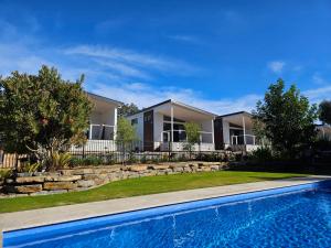 a house with a swimming pool in front of a house at Murray Bridge Tourist Park - Adult Only in Murray Bridge