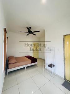 um quarto com uma cama e uma ventoinha de tecto em Homestay Bukit Roses em Beranang