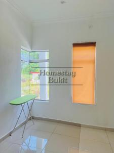 um quarto com uma mesa e uma janela em Homestay Bukit Roses em Beranang