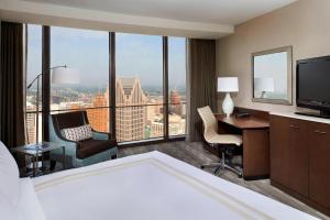 a hotel room with a bed and a desk with a view at Detroit Marriott at the Renaissance Center in Detroit