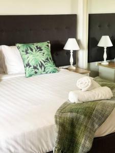 a bedroom with a large white bed with two lamps at Suburban Bliss - Elegant Villa 2 in Wagga Wagga