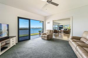 a living room with a couch and a tv at Jeffery River Retreat - Best Sunsets in Yamba in Yamba