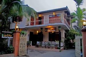 uma casa com um portão em frente em Manichan Guesthouse em Luang Prabang