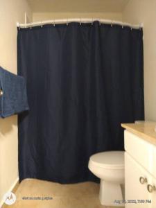 bagno con tenda doccia nera e servizi igienici di Ocean view condo 