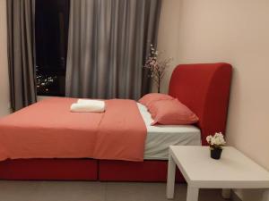 1 dormitorio con 1 cama con silla roja y mesa en KB2712 - Cyberjaya-Netflix-Wifi- Parking-Pool, 1011, en Cyberjaya