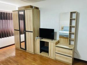 a living room with a tv and a mirror at Muangthong C3near Impact in Nonthaburi
