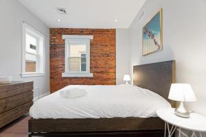 um quarto com uma cama e uma parede de tijolos em Lofts at Walnut: 1BR Fast Wi-Fi em Harrisburg