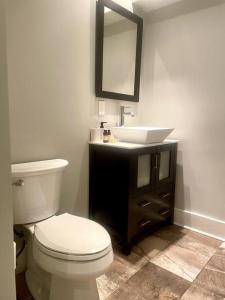 y baño con aseo blanco y lavamanos. en Urban Retreat: 2BR in DWTN HBG en Harrisburg