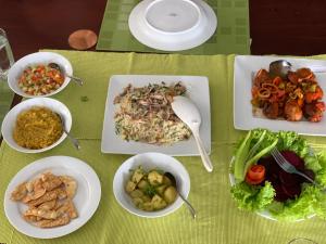 una mesa con platos de comida y tazones de comida en Eastland Bungalow, Hewaheta, Kandy en Hewaheta
