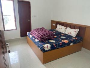 Monga Hotel & Paradise في Hanumāngarh: غرفة نوم بسرير مع اطار خشبي