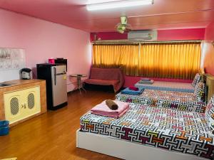 um quarto com uma cama e um frigorífico em Muangthong C3near Impact em Nonthaburi