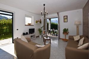 un salon avec deux canapés et une télévision dans l'établissement Fiorita Apartments with Shared Pool, à Colico