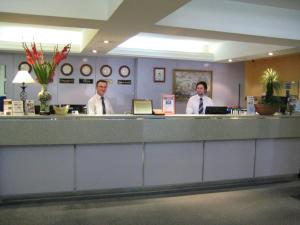 three men are standing at a reception counter in a hospital at Devere Hotel in Sydney