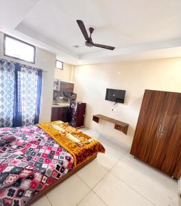 Schlafzimmer mit einem Bett und einem Flachbild-TV in der Unterkunft SP VILLA -- LPU Law Gate -- Near Jhally Hair Craze Salon & Tattoo in Phagwara