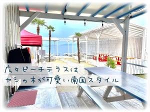 a picnic table with chinese writing on it on a patio at ビーチハウス at ワニベース in Otsu