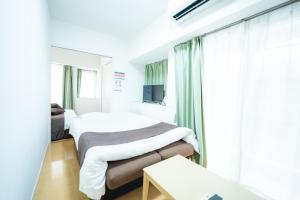 a hospital room with two beds and a window at Smart Vacation Canaan A スマートバケーション　カナン A in Kagoshima