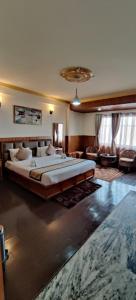 een grote slaapkamer met een groot bed in een kamer bij Hotel Kasturi Palace & Restaurant Darjeeling in Darjeeling