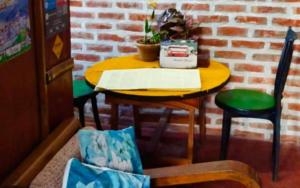 a yellow table with a chair and a table with a plant at Koilee Homestead by StayApart in Darjeeling