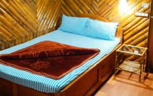 Cama en habitación con pared de madera en Koilee Homestead by StayApart, en Darjeeling
