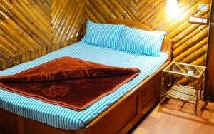 a bed in a room with a wooden wall at Koilee Homestead by StayApart in Darjeeling