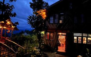a house with lights on the side of it at night at Koilee Homestead by StayApart in Darjeeling +31 photos