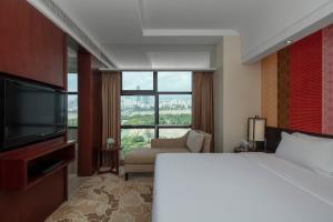 Habitación de hotel con cama y ventana grande en Radisson Blu Hotel Liuzhou en Liuzhou