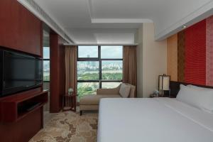 Habitación de hotel con cama y ventana grande en Radisson Blu Hotel Liuzhou, en Liuzhou